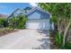 Two-story home with white garage door, blue siding, and lush landscaping in front at 4611 Eaglet Ln, Kissimmee, FL 34746