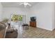 Bright living room featuring wood-look tile floors and sliding glass doors to lanai at 4611 Eaglet Ln, Kissimmee, FL 34746