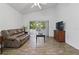 Bright living room featuring wood-look tile floors and sliding glass doors to lanai at 4611 Eaglet Ln, Kissimmee, FL 34746