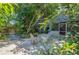 Landscaped backyard patio shaded by mature trees, complete with dining table and chairs, near the screened-in porch at 4611 Eaglet Ln, Kissimmee, FL 34746