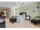 Spacious bedroom with a comfortable bed, stylish nightstand, a cozy lounge chair, and warm tile flooring at 615 Copeland Dr, Haines City, FL 33844