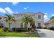 Charming two-story home featuring lush landscaping, palm trees, and a well-manicured lawn at 615 Copeland Dr, Haines City, FL 33844