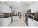 Bright kitchen featuring tile backsplash, white cabinets, and stainless steel appliances at 615 Copeland Dr, Haines City, FL 33844