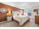 Serene main bedroom with a textured accent wall, a cozy chair, and soft lighting at 615 Copeland Dr, Haines City, FL 33844