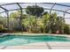 Pool area with lush landscaping and a screened enclosure for a private and serene outdoor experience at 615 Copeland Dr, Haines City, FL 33844