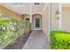 Paver walkway leading to the front door of a well-maintained townhome, with lush landscaping at 6873 Slaven Dr, Orlando, FL 32819