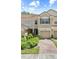 Charming two-story townhouse with a tile roof, single car garage, and manicured bushes in front at 6873 Slaven Dr, Orlando, FL 32819