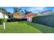 Exterior shot of manicured backyard and orange home with clipped bushes and green lawn at 7422 Sparkling Ct, Reunion, FL 34747