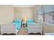 Bright bedroom features twin beds, a window with blinds, and a side table at 7422 Sparkling Ct, Reunion, FL 34747