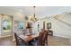 This dining room features a wooden table, a chandelier, and stairs at 7422 Sparkling Ct, Reunion, FL 34747