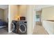 Upstairs laundry area with side-by-side washer and dryer, next to a hallway leading to additional rooms at 7422 Sparkling Ct, Reunion, FL 34747