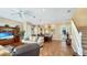 Open-concept living room with tile floors, a cozy sofa, and direct access to the dining area and staircase at 7422 Sparkling Ct, Reunion, FL 34747