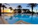 Relaxing community pool featuring lounge chairs and umbrellas to enjoy under a beautiful sunset at 7422 Sparkling Ct, Reunion, FL 34747