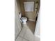 Small powder room features beige tile flooring and toilet, accented with a light towel and minimalist decor at 773 Leopard Ct, Kissimmee, FL 34759