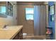 Shower stall and a sink with dark cabinets in a bright bathroom with neutral tile and modern fixtures at 805 Hemlock Dr, Apopka, FL 32712