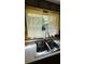 Kitchen sink offers a garden view through sheer curtains, bringing natural light into the space at 805 Hemlock Dr, Apopka, FL 32712
