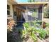 Enjoy the outdoors on this screened porch, surrounded by garden plants and cozy lighting at 805 Hemlock Dr, Apopka, FL 32712