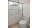 Bright bathroom features a tiled shower and tub combination with a safety bar and glass door at 8724 Peachtree Park Ct, Windermere, FL 34786