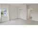 This bedroom has a large window letting in lots of natural light, neutral carpeting, and a closet at 8724 Peachtree Park Ct, Windermere, FL 34786