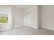 Carpeted bedroom features a large window with white curtains and a closet at 8724 Peachtree Park Ct, Windermere, FL 34786