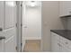 Hallway with hardwood floors, white cabinetry with dark countertops, and white doors at 8724 Peachtree Park Ct, Windermere, FL 34786