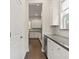 Hallway with gray countertops, white cabinetry, and stainless wine cooler at 8724 Peachtree Park Ct, Windermere, FL 34786