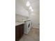 Well-equipped laundry room with modern side-by-side washer and dryer at 8724 Peachtree Park Ct, Windermere, FL 34786