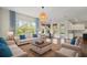 A bright and airy living room with hardwood floors, blue accents, and an adjacent dining area at 8724 Peachtree Park Ct, Windermere, FL 34786