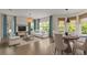 Open-concept living and dining area featuring hardwood floors, large windows, and comfortable seating at 8724 Peachtree Park Ct, Windermere, FL 34786