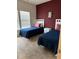 Bright bedroom featuring two twin beds with navy comforters and a charming Disney-themed picture on a burgundy wall at 8981 Shine Dr, Kissimmee, FL 34747