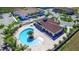 Aerial view of a community pool area with lounge chairs, a hot tub, and lush landscaping at 8981 Shine Dr, Kissimmee, FL 34747