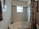 Bathroom with a tub and shower, white tile, and gray accents for a clean, functional space at 921 Louisiana Ave, St Cloud, FL 34769