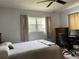 Bedroom featuring a comfy bed, wooden furniture, and bright window, ideal for relaxation and rest at 921 Louisiana Ave, St Cloud, FL 34769