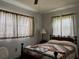 Bedroom with a bed, two windows with fabric drapes, a ceiling fan and a bedside lamp at 921 Louisiana Ave, St Cloud, FL 34769
