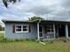Close up of charming one-story home with covered entry and red shutters at 921 Louisiana Ave, St Cloud, FL 34769