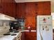 Kitchen with white appliances, marble countertop, and wood cabinetry at 921 Louisiana Ave, St Cloud, FL 34769
