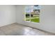 Well-lit bedroom featuring tile flooring and a large window, offering a simple and comfortable living space at 12513 Indiana Woods Ln, Orlando, FL 32824