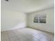 Serene bedroom with natural light, tile floors and a large window overlooking the lush surroundings at 12513 Indiana Woods Ln, Orlando, FL 32824