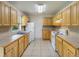 Functional kitchen featuring tile countertops, white appliances, and ample cabinet space for storage at 12513 Indiana Woods Ln, Orlando, FL 32824