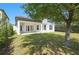 A well-manicured backyard has green grass, mature trees, and a covered patio at 12755 Westside Village Loop, Windermere, FL 34786