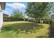 A lush backyard features green grass, mature trees, and a black metal fence at 12755 Westside Village Loop, Windermere, FL 34786