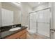 Bathroom with wood cabinets, black granite countertop, and a glass-enclosed shower at 12755 Westside Village Loop, Windermere, FL 34786