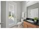 Bathroom with wood cabinets, black granite countertop, and a glass door to the lanai at 12755 Westside Village Loop, Windermere, FL 34786