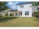 A two-story home with a covered patio has a lush lawn and mature trees in the backyard at 12755 Westside Village Loop, Windermere, FL 34786