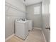 Laundry room with washer, dryer, wood-look floors and metal shelving at 12755 Westside Village Loop, Windermere, FL 34786