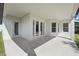 A covered patio features white walls, recessed lighting, concrete flooring, and glass doors at 12755 Westside Village Loop, Windermere, FL 34786