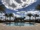 A community pool with crystal clear water features a gazebo and surrounding palm trees at 12755 Westside Village Loop, Windermere, FL 34786