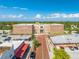 Aerial view of the St. Cloud City Hall, a large brick building with parking, trees, and downtown buildings nearby at 1422 Missouri Ave, St Cloud, FL 34769