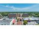 Aerial view of the St. Cloud City Hall, a large brick building with a parking lot, trees, and downtown buildings nearby at 1422 Missouri Ave, St Cloud, FL 34769