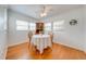 A dining room featuring wood floors, white walls, three windows and a ceiling fan at 1422 Missouri Ave, St Cloud, FL 34769